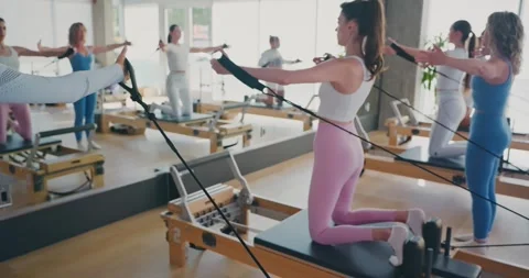 Pilates Class Using Reformers in Modern Studio Stock Footage 323929240