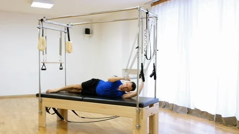 Pilates instructor performing exercise on fitness equipment Stock Footage 87056932