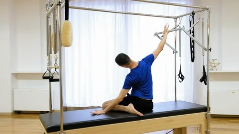 Pilates instructor performing exercise on fitness equipment Stock Footage 87063387