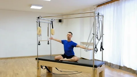 Pilates instructor performing exercise on fitness equipment Stock Footage 87068682