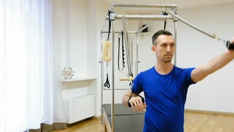 Pilates instructor performing exercise on fitness equipment Stock Footage 87128971