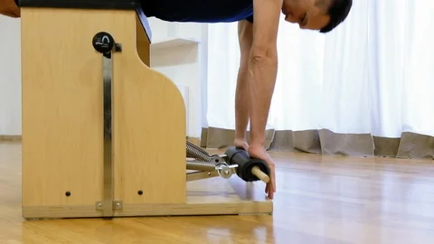 Pilates instructor performing exercise on fitness equipment Stock Footage 87148286