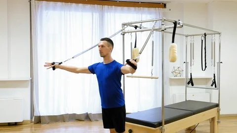 Pilates instructor performing exercise on fitness equipment Stock Footage 87366901