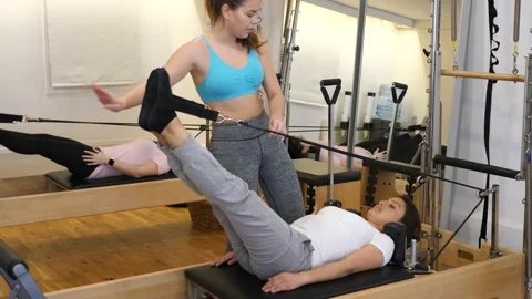 Pilates instructor training women at the gym Stock Footage
