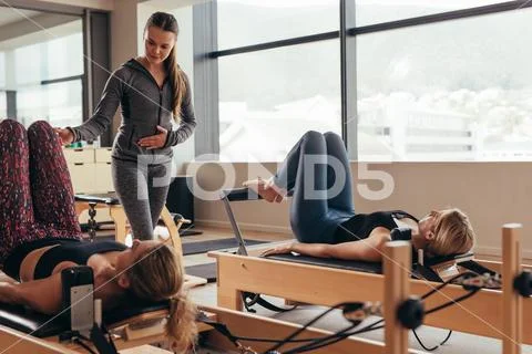 Pilates instructor training women at the gym Stock Photos
