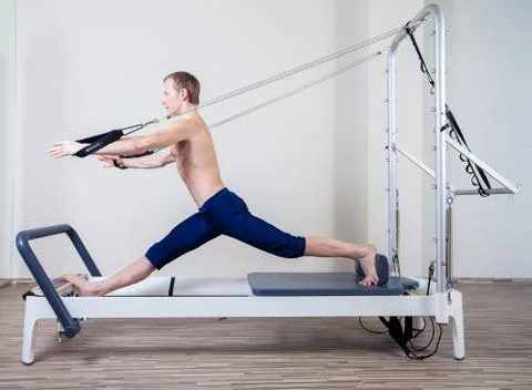 Pilates reformer workout exercises man at gym indoor Stock Photos