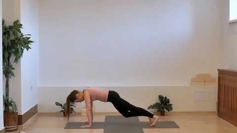 Pilates teacher in the studio on a yoga mat performs an abdominal press study in Stock Footage 127853473