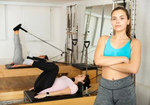 Pilates trainer posing against the background of training people in gym Foto stock