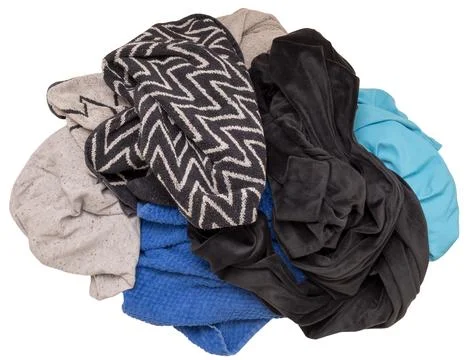 A pile of assorted cloths sits on a clear background. The fabrics include var Foto stock
