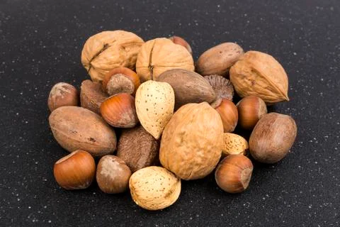 Pile of assorted nuts in the shell isolated over black Stock Photos