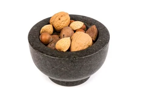 Pile of assorted nuts in the shell in a mortar bowl isolated over white Stock Photos