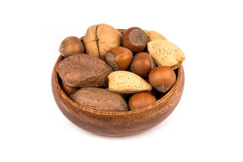 Pile of assorted nuts in the shell in a wood bowl isolated over white Stock Photos