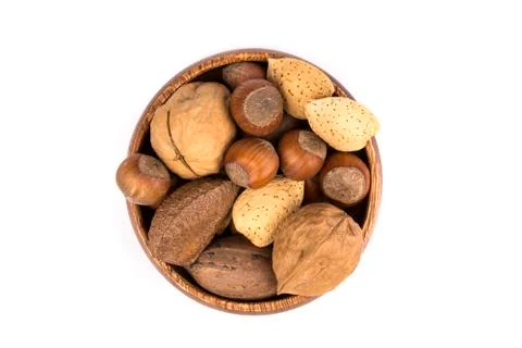 Pile of assorted nuts in the shell in a wood bowl isolated over white Stock Photos