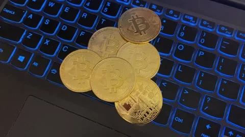 Pile of Bitcoins on a Lit Computer Keyboard Stock Footage 159359617