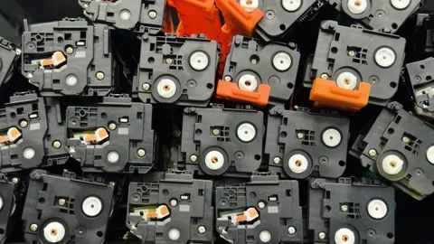 A pile of black printer cartridges with white rollers and orange clips  Stock Footage 341950178