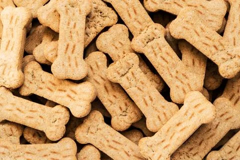 Pile of Bone shaped dog biscuits of brown color. Abstract wallpaper. Stock Photos