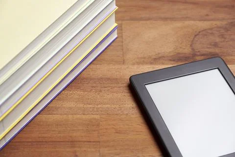 Pile of books and electronic reader with blank screen on a wooden surface Foto stock