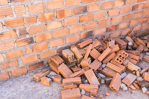Pile of bricks in construction site with brick wall background Foto stock