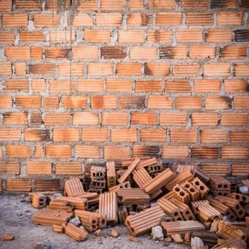 Pile of bricks in construction site with brick wall background Foto stock