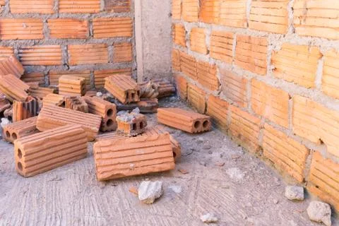 Pile of bricks in construction site with brick wall background 写真素材