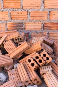 Pile of bricks in construction site with brick wall background 写真素材