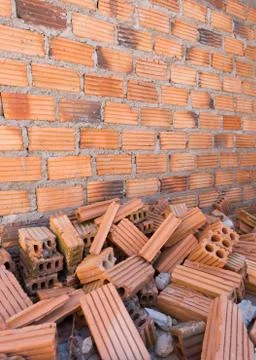 Pile of bricks in construction site with brick wall background Stockfoto's
