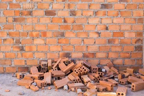 Pile of bricks in construction site with brick wall background 写真素材