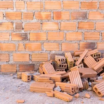 Pile of bricks in construction site with brick wall background 스톡 사진