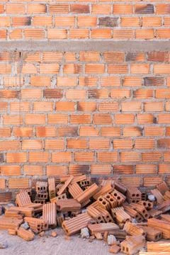 Pile of bricks in construction site with brick wall background Stockfoto's