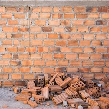 Pile of bricks in construction site with brick wall background Foto stock