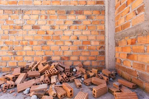 Pile of bricks in construction site with brick wall background 写真素材
