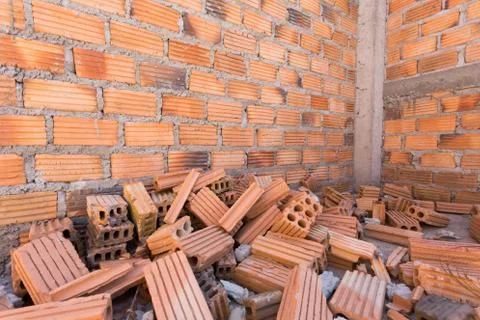 Pile of bricks in construction site with brick wall background Foto stock
