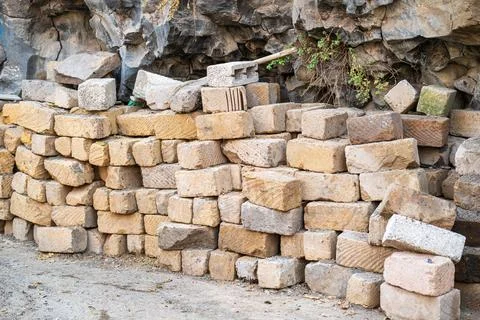 A pile of bricks is stacked up against a wall Stock Photos