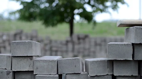 Pile of the bricks with the tree on the background at windy day. Steady shot Stock Footage 62822984