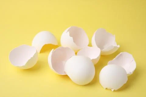Pile of broken eggshells on yellow background, closeup 스톡 사진