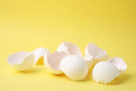 Pile of broken eggshells on yellow background, closeup 스톡 사진