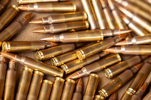 Pile of bullets with copper tips under a warm light. Close up of a lot of bul Stock Photos