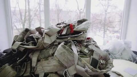 Pile of camouflage parachute rucksacks on table in workshop Stock Footage 236907735