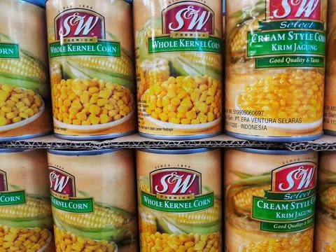 Pile of Canned Corn Whole Kernel and Cream Style on supermarket. Stock Photos