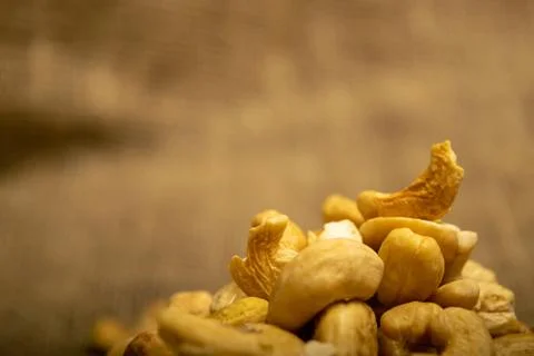 A pile of cashew nuts on burlap with a rough texture surface texture. Close u Stock Photos