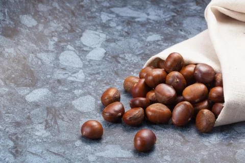 Pile of chestnuts on stone texture floor with copy space Stock Photos