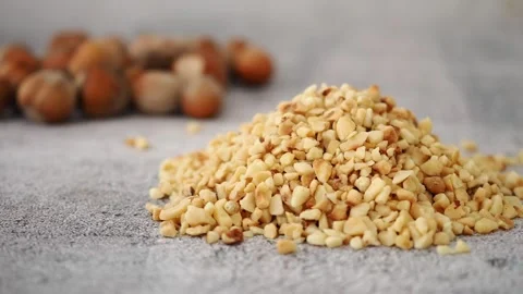 Pile of Chopped Hazelnuts with Whole Nuts in the Background Stock Footage 335613104