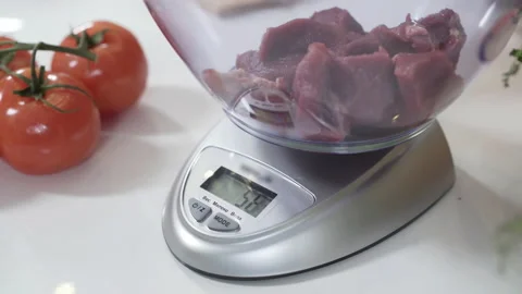 Pile of chopped meat on electronic scale in kitchen. Standing on flat weighing Stock Footage 130242162