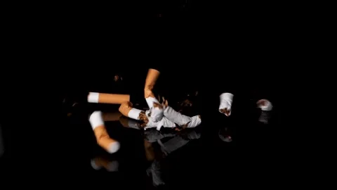 A pile of cigarette butts falling in slow motion on black surface. Stock Footage 148724819