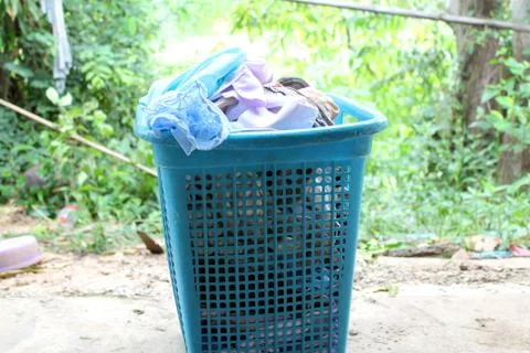 Pile of clothes overflow plastic laundry basket for washing Foto stock