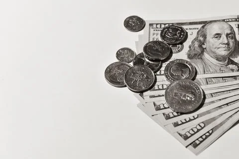 Pile of coins and a stack of one hundred dollar bills Stock Photos