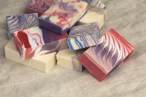 Pile of cold process design soaps on display on linen backdrop 库存照片