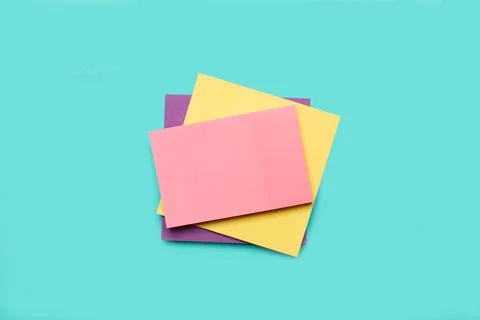 A pile of colored paper notes on a light blue background Stock Photos