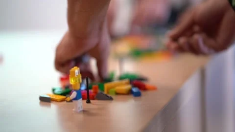Pile of colorful interlocking plastic bricks and shapes on table and one Stock Footage 131160056