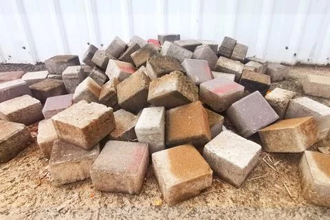 Pile of Construction Bricks Laying On The Ground With White Metal Sheet Wall Stock Photos
